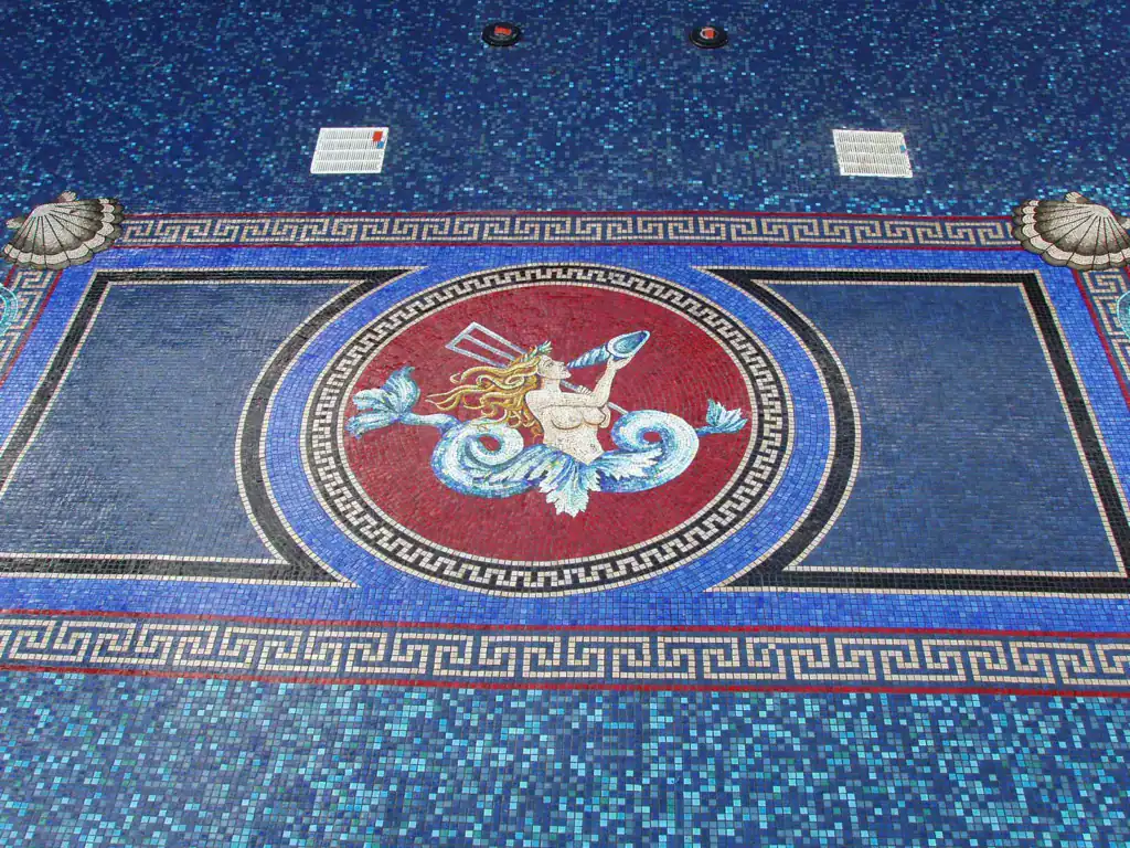 Mosaic logo featuring a mythical creature in a circular design, showcasing intricate tile work and v.